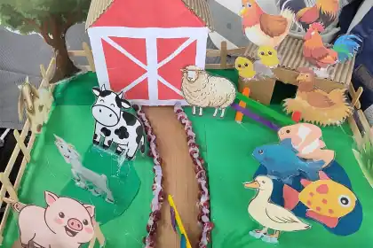 A farm storybook scene with toy animals